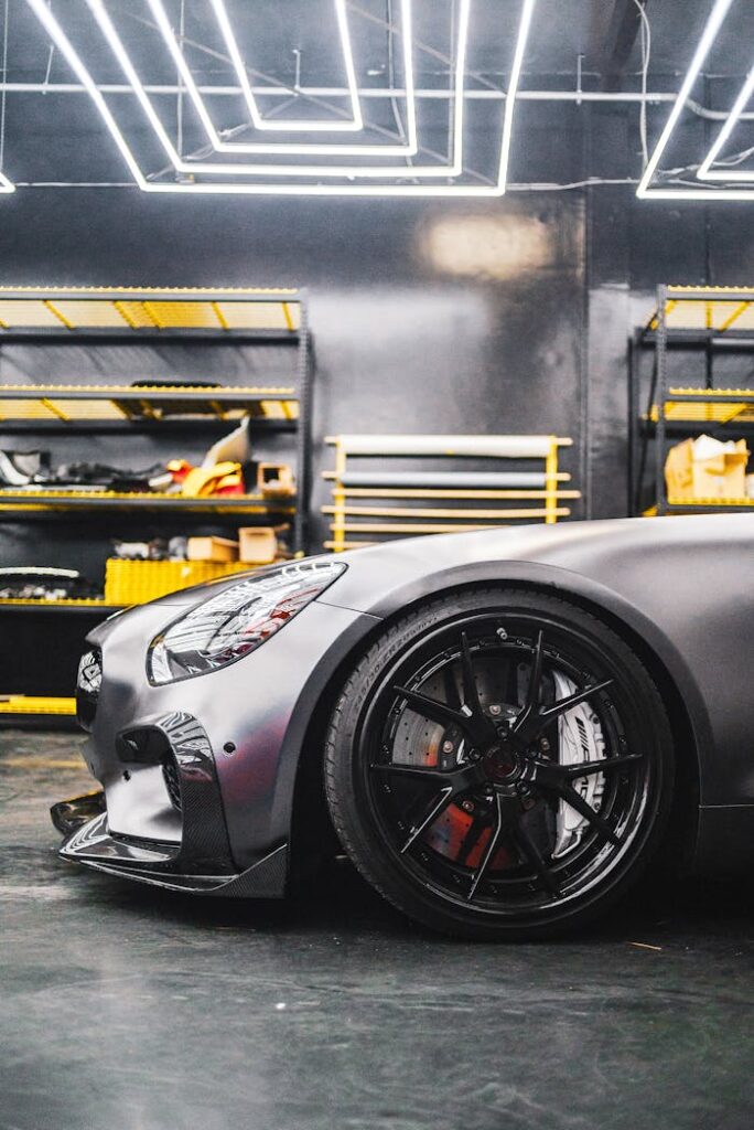 Close-up of a sleek sports car in a contemporary garage environment with industrial lighting.