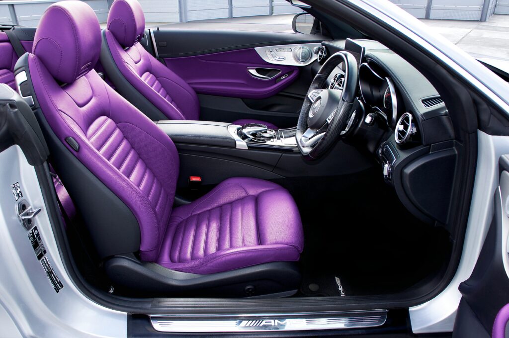 Sleek car interior featuring vibrant purple leather seats and modern design elements.