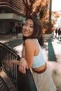 Young woman smiling while leaning on railing in sunlight, São Paulo.